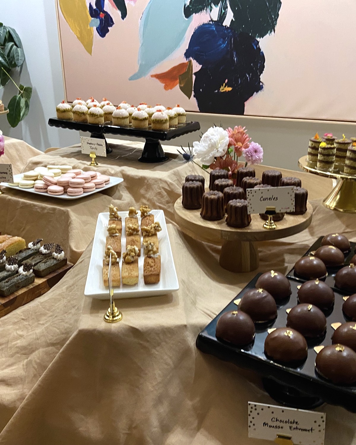 Wedding dessert table with assorted small bites and floral arrangements